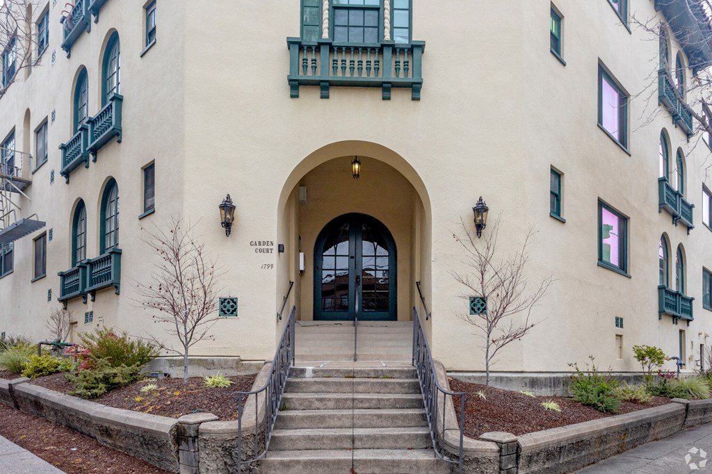 the front of a building with stairs and a large arched doorway