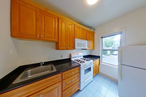 A kitchen with wooden cabinets and a white refrigerator.