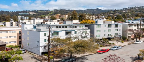 A parking lot with cars and apartment buildings in the background.