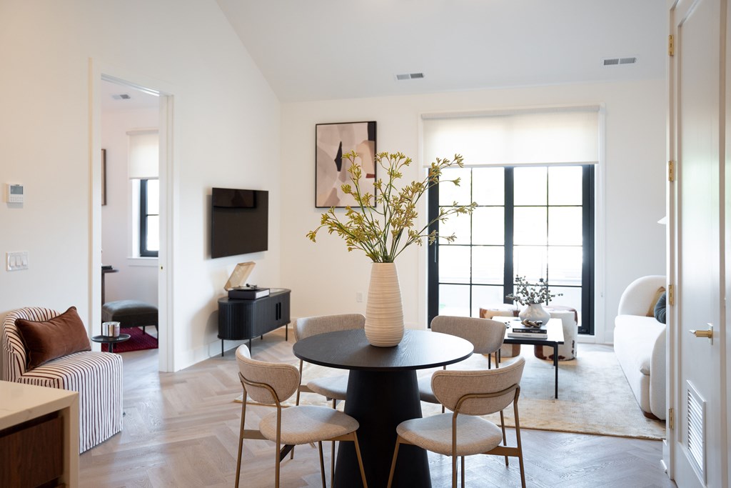 A living room with a black table and chairs.