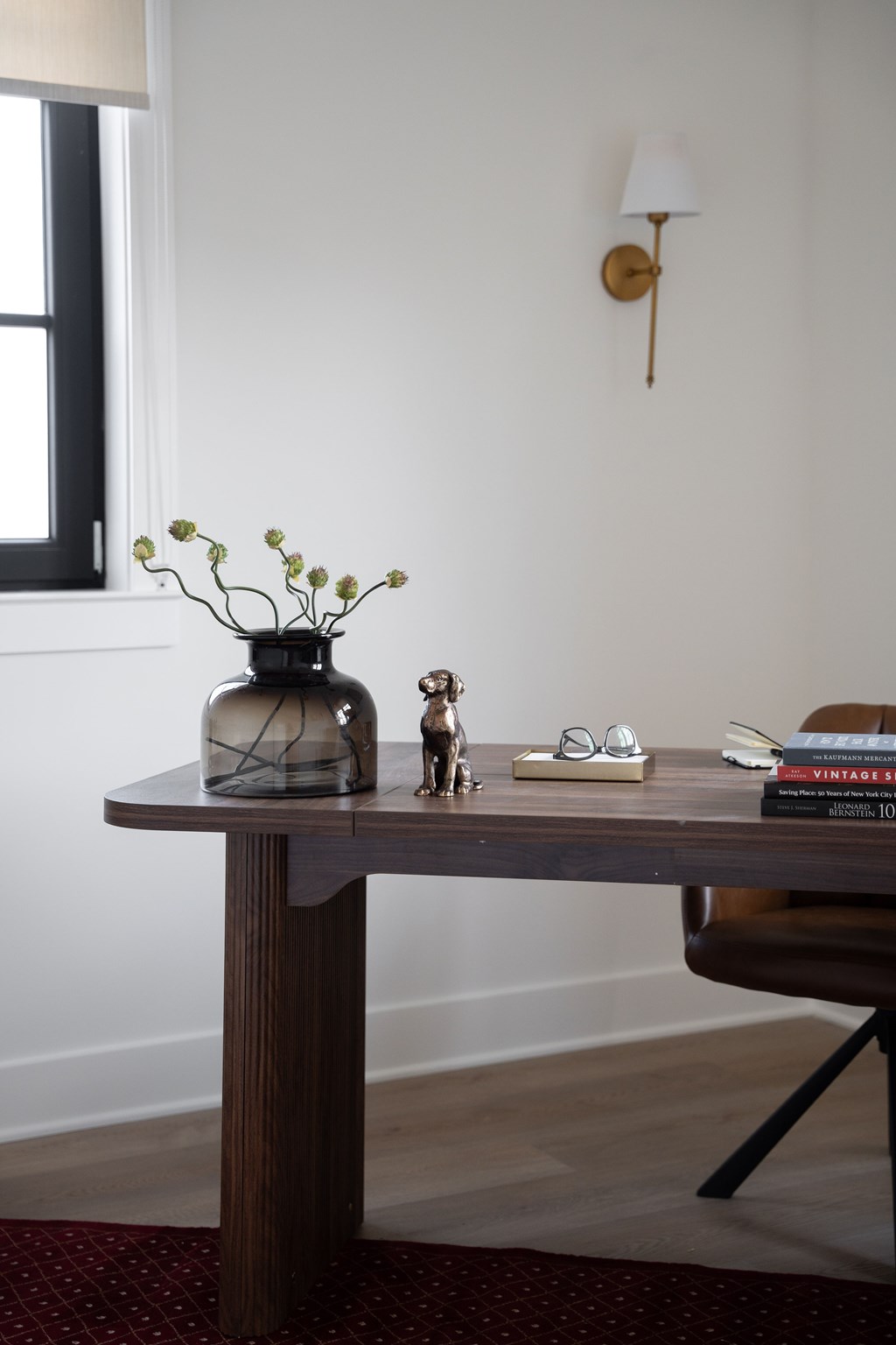 A table with a vase, a book, and a small statue on it.