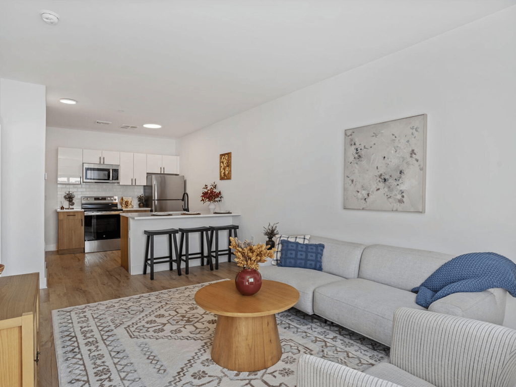 a living room and kitchen with a couch and a table