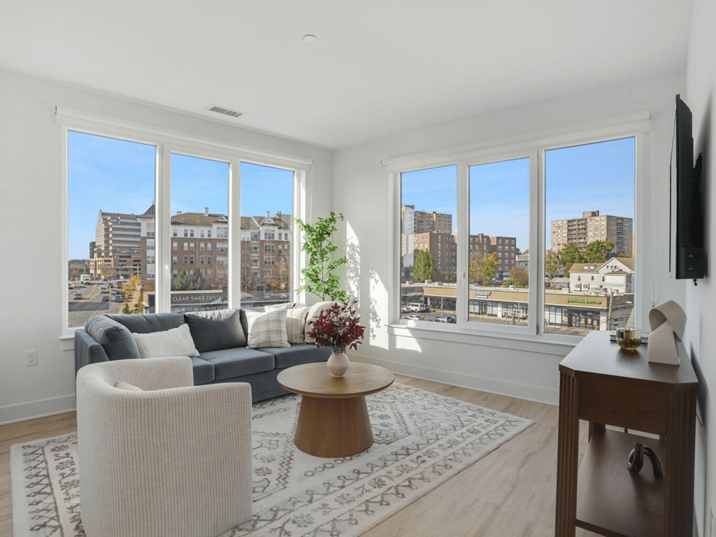 a living room with a couch and a table and a view of the city