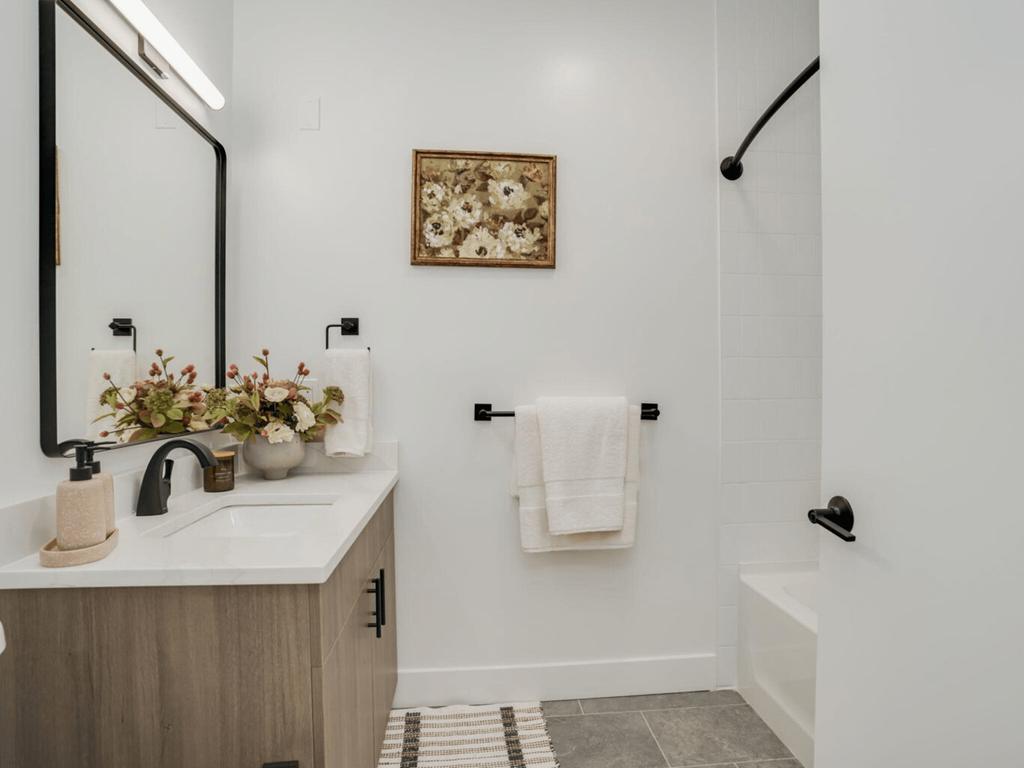 a bathroom with a sink and a mirror and a shower