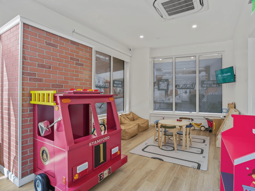 a play room with a toy truck in front of a brick wall
