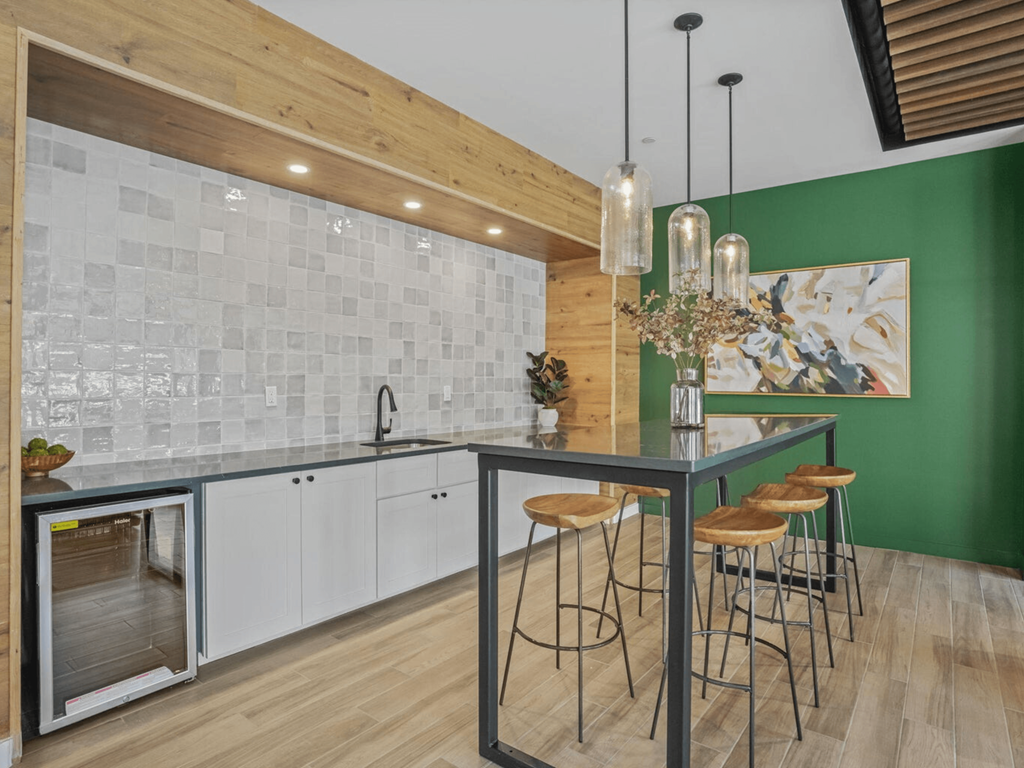 a kitchen with green walls and a bar with stools