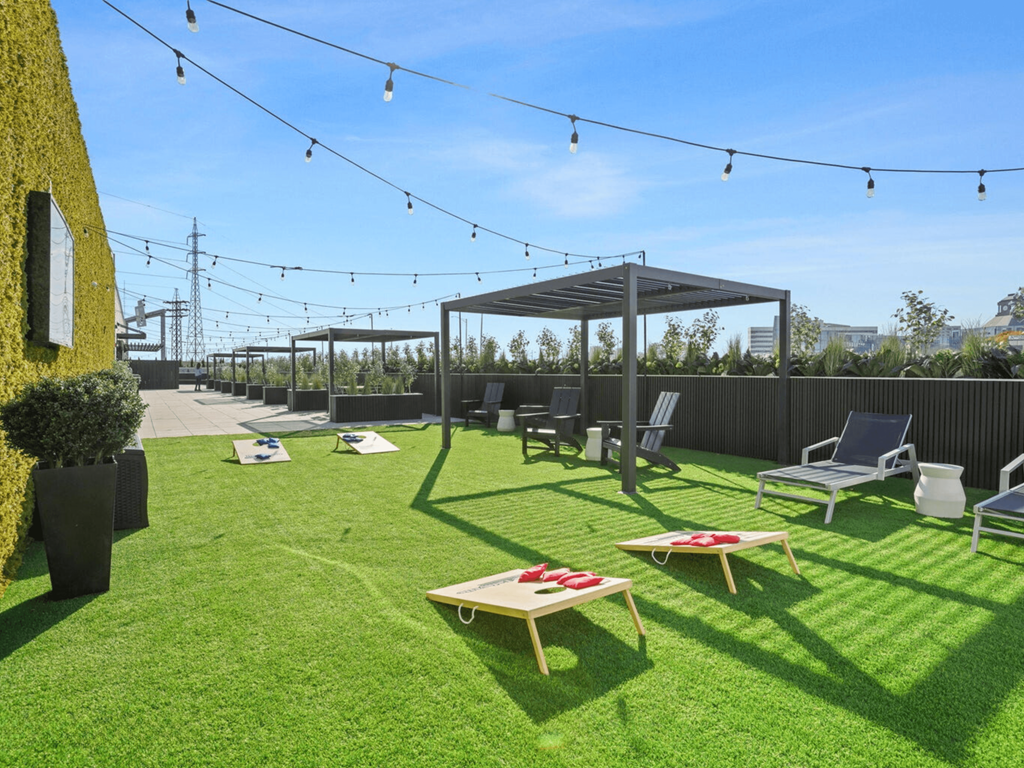 a lounge area with tables and chairs on the grass