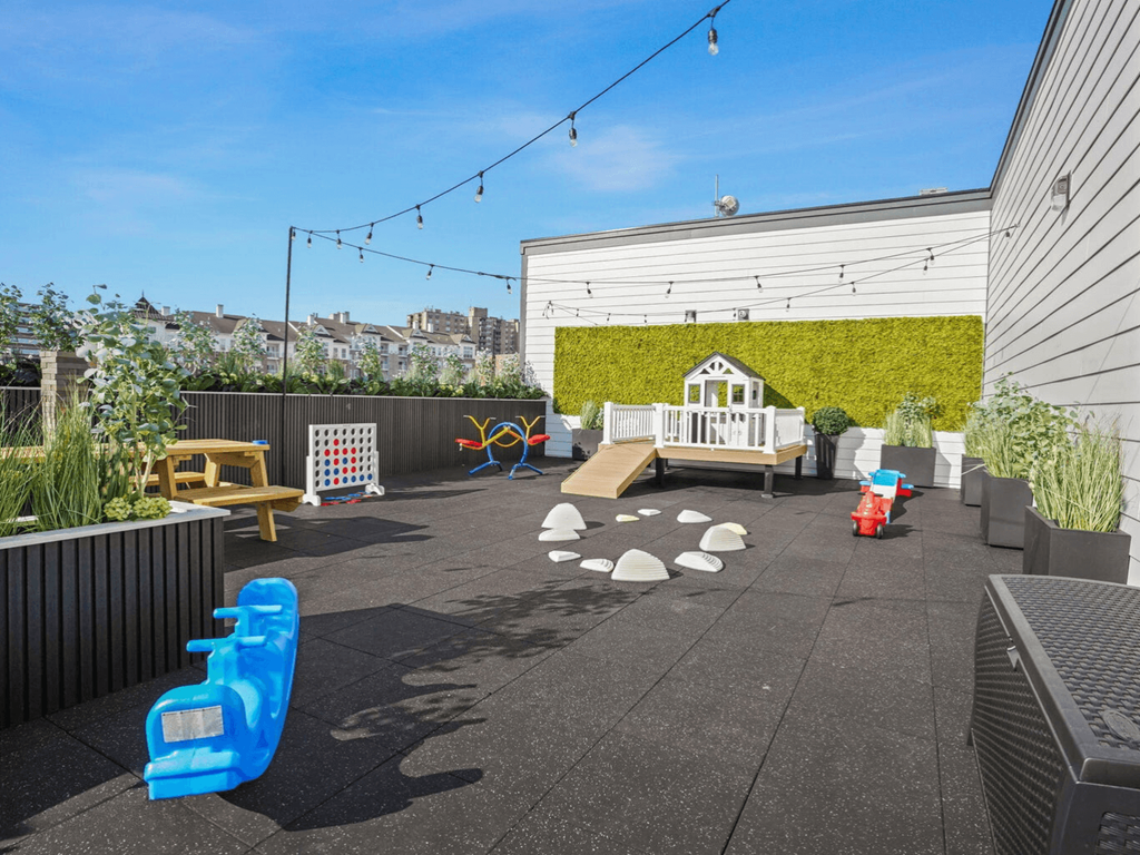 the backyard has a play area with a swing set and a childs playhouse