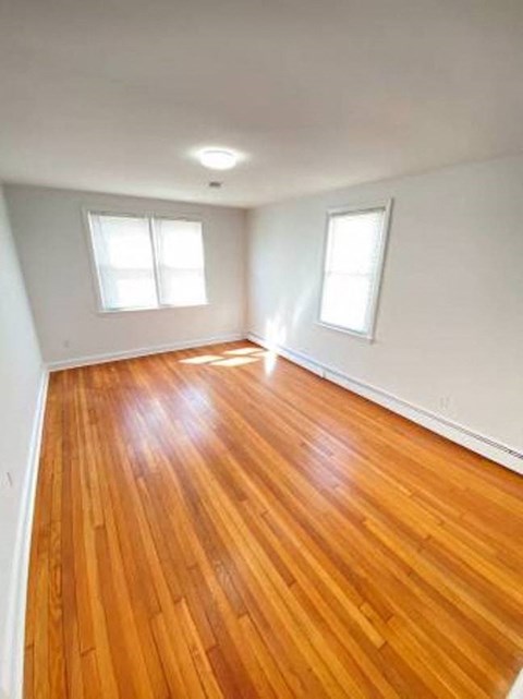 an empty living room with a wooden floor
