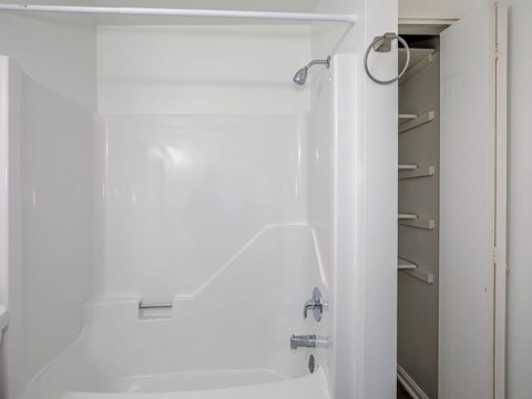 A white bathtub with a shower head and a faucet.