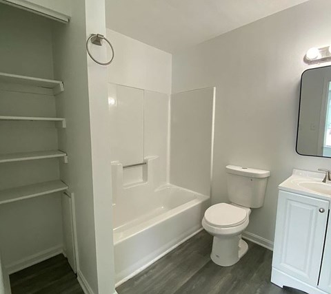 A white bathroom with a toilet, sink, and bathtub.