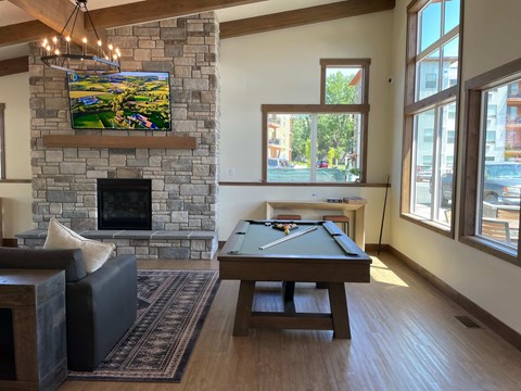 A living room with a fireplace and a tv mounted above it.
