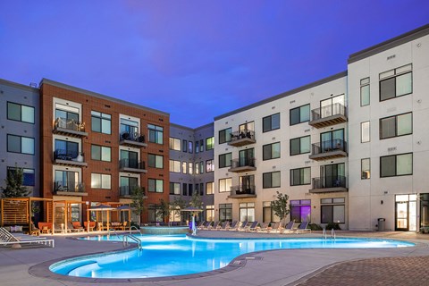 A swimming pool in front of apartment buildings.