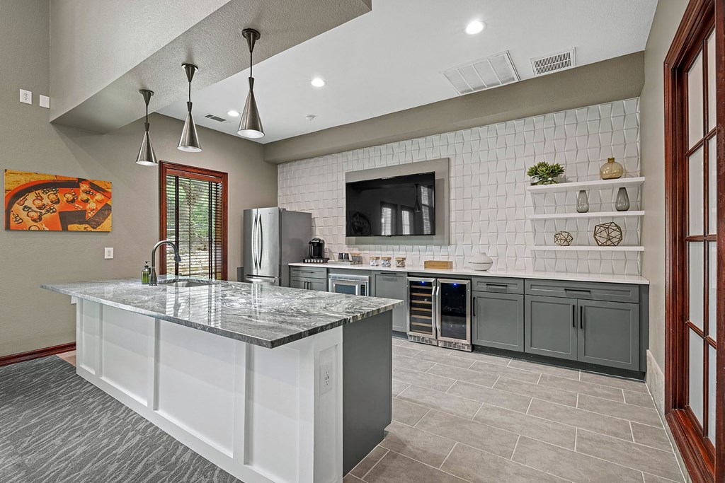 A kitchen with a marble countertop and a refrigerator.