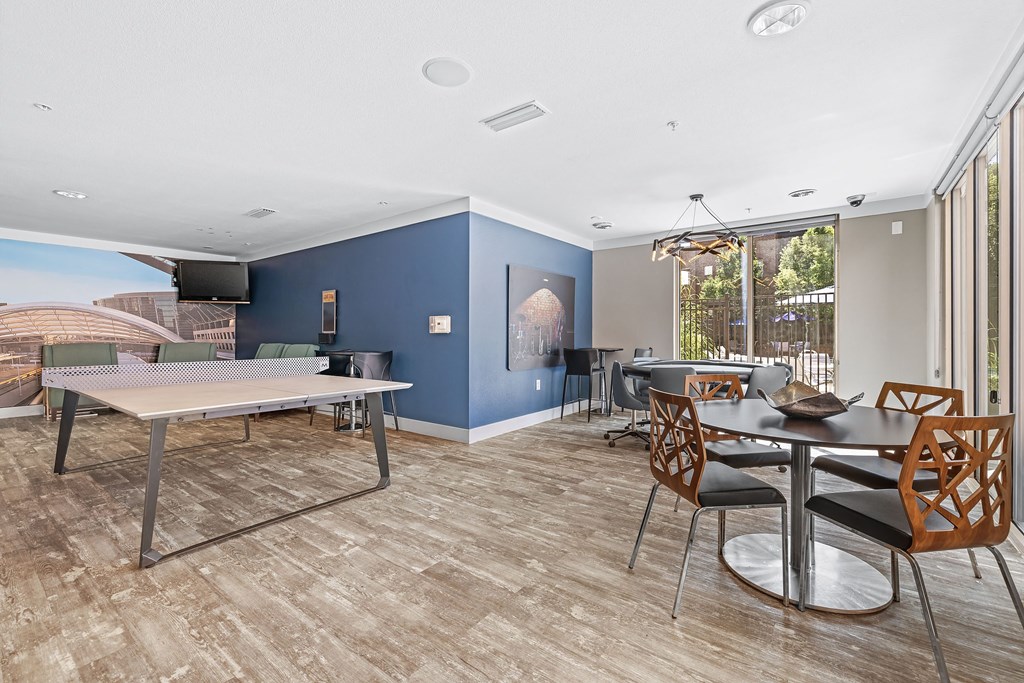 a living room with a dining room table and a ping pong table