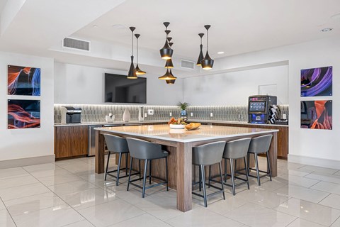 a large kitchen with a bar and chairs