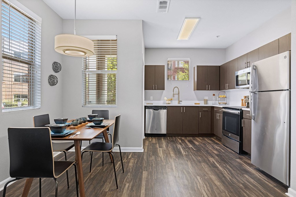 a kitchen and dining room with stainless steel appliances and a table and chairs