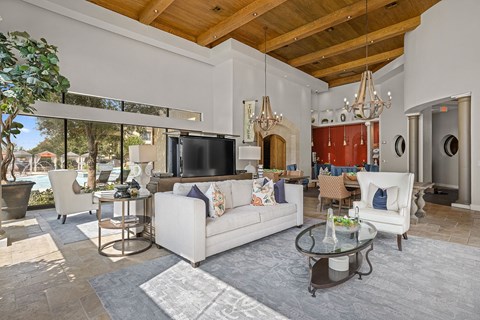 A modern living room with a white sofa and a glass coffee table.