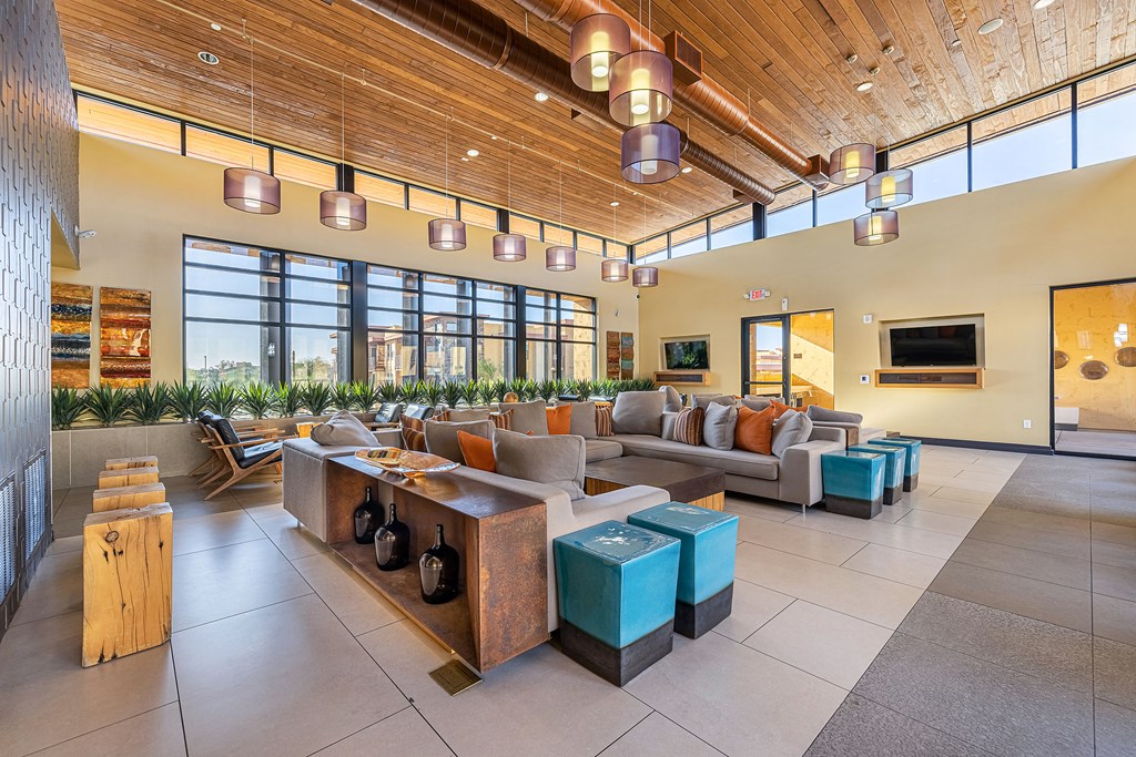 a living room with couches and tables and large windows