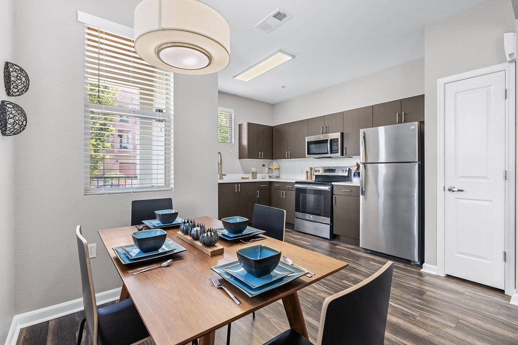a kitchen and dining room with stainless steel appliances and a table and chairs