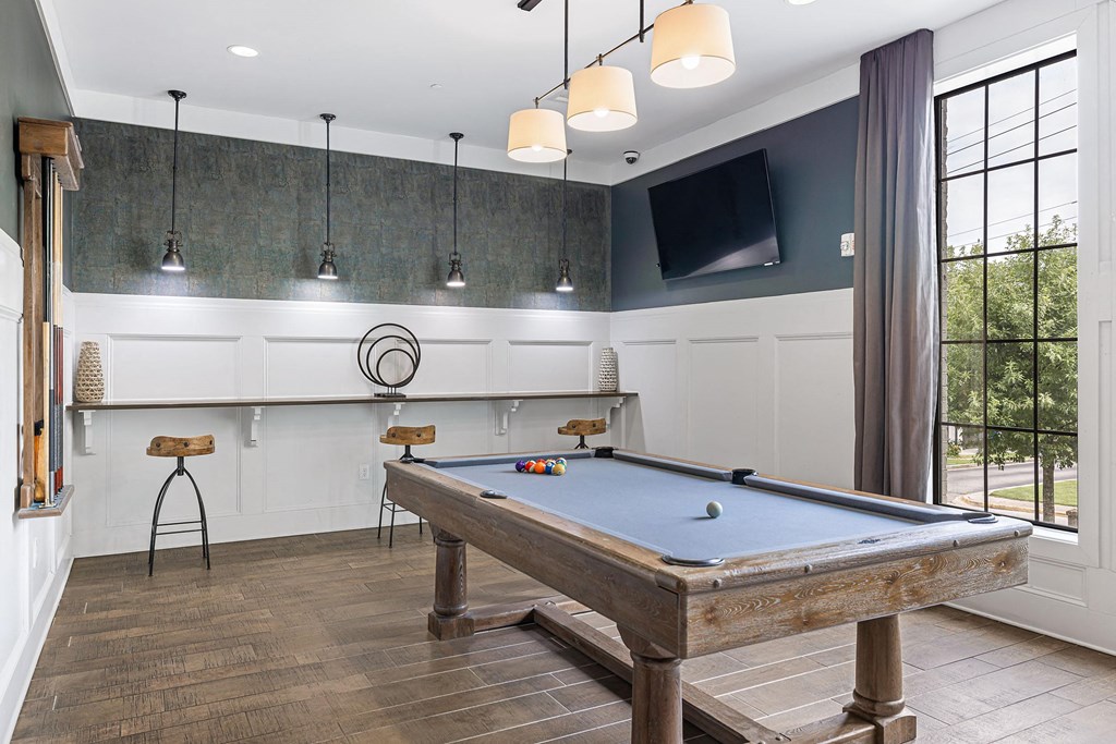 a game room with a pool table and a tv