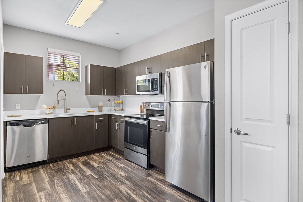 a kitchen with stainless steel appliances and wooden floors