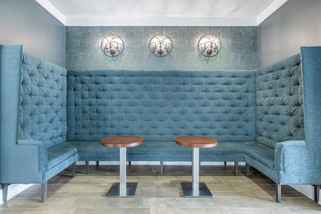 a seating area with two stools in a room with blue chairs