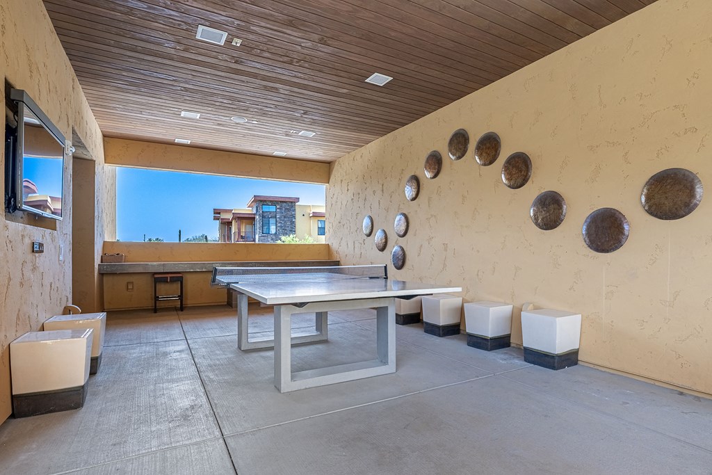 a ping pong table in a room with a wall with disks on it
