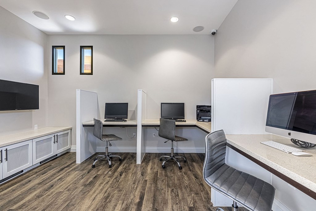 an office with two computers and a desk with a monitor