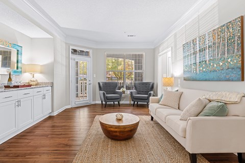 A living room with a white couch and a wooden coffee table.