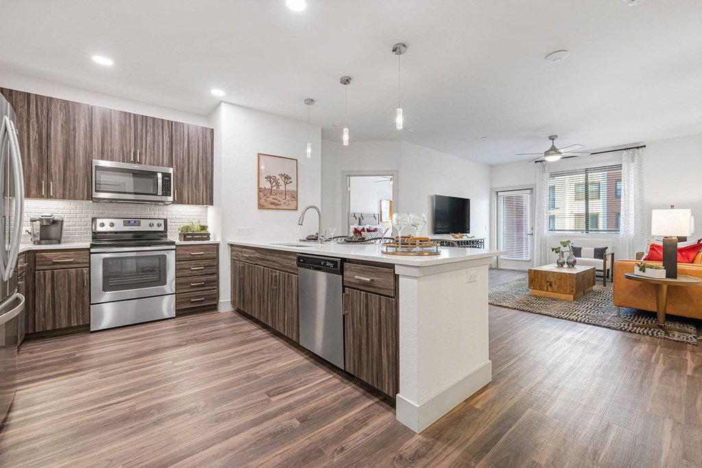 a kitchen with stainless steel appliances and wooden floors