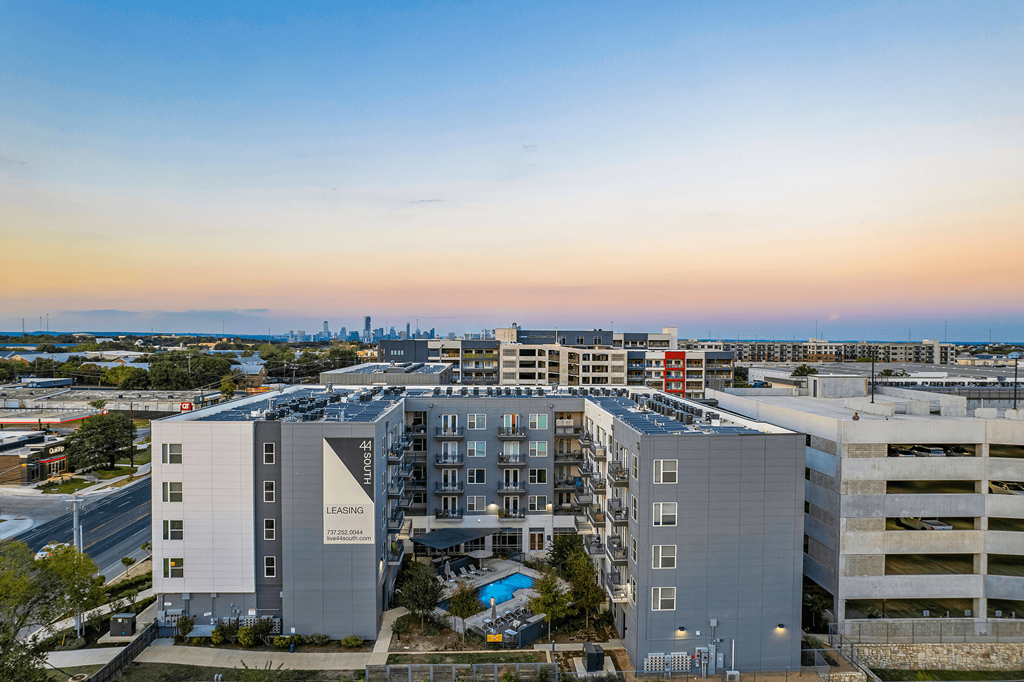 an aerial view of an apartment building with a sunset in the background