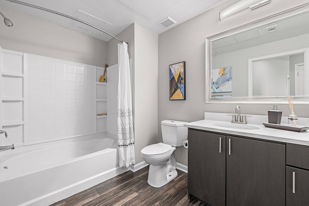 a bathroom with a toilet sink and shower and a mirror