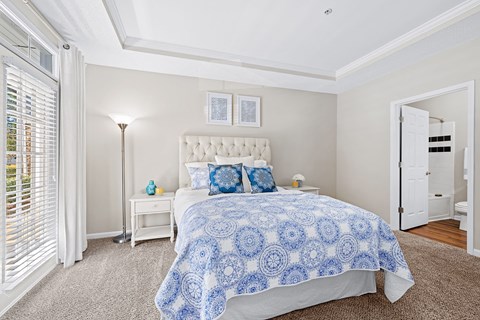 A bedroom with a large bed and a white headboard.