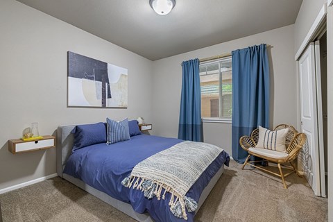 a bedroom with a bed and a chair and a window