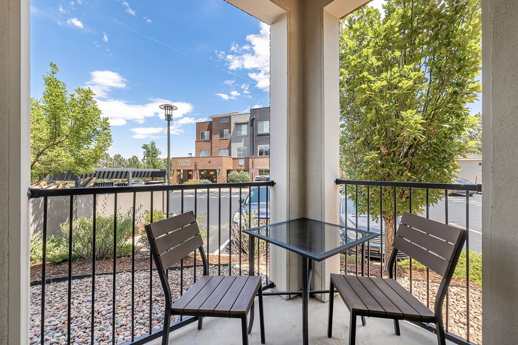 a patio with two chairs and a table on a balcony