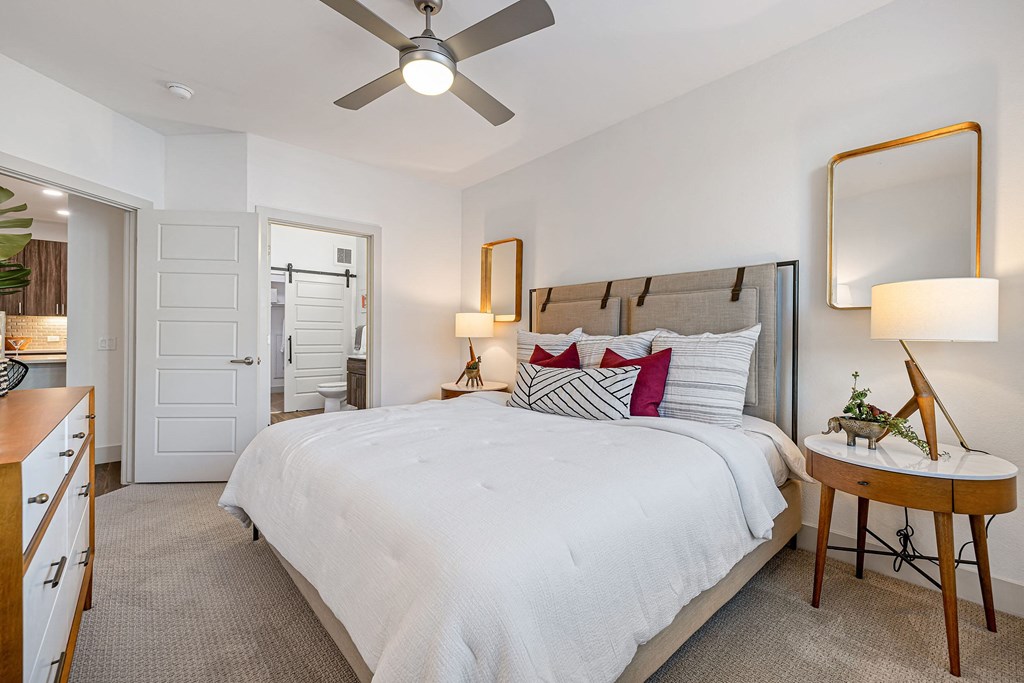 a bedroom with a large bed and a ceiling fan