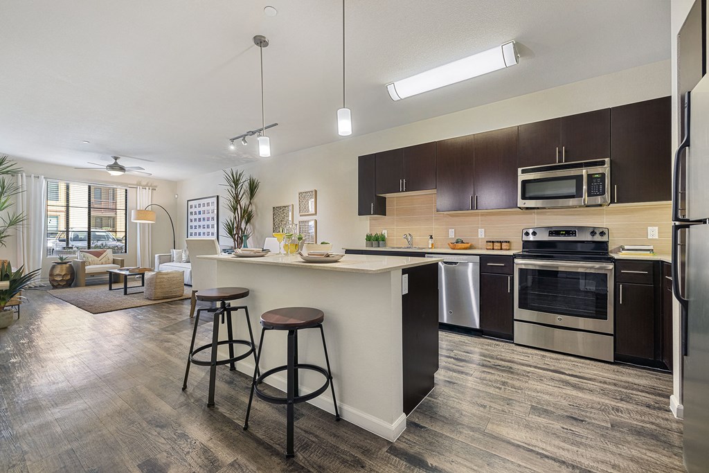 an open kitchen and living room with a bar and stools