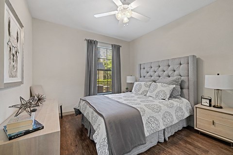 A bedroom with a large bed and a ceiling fan.