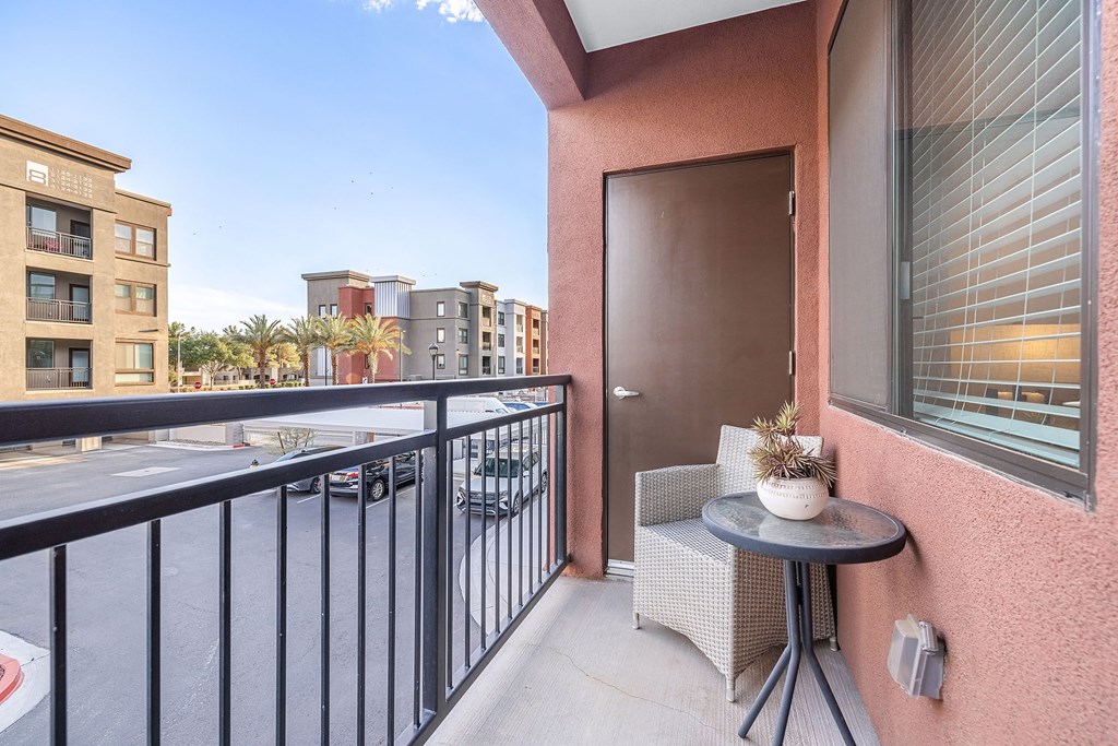 a balcony with a table and a chair and a view of the street