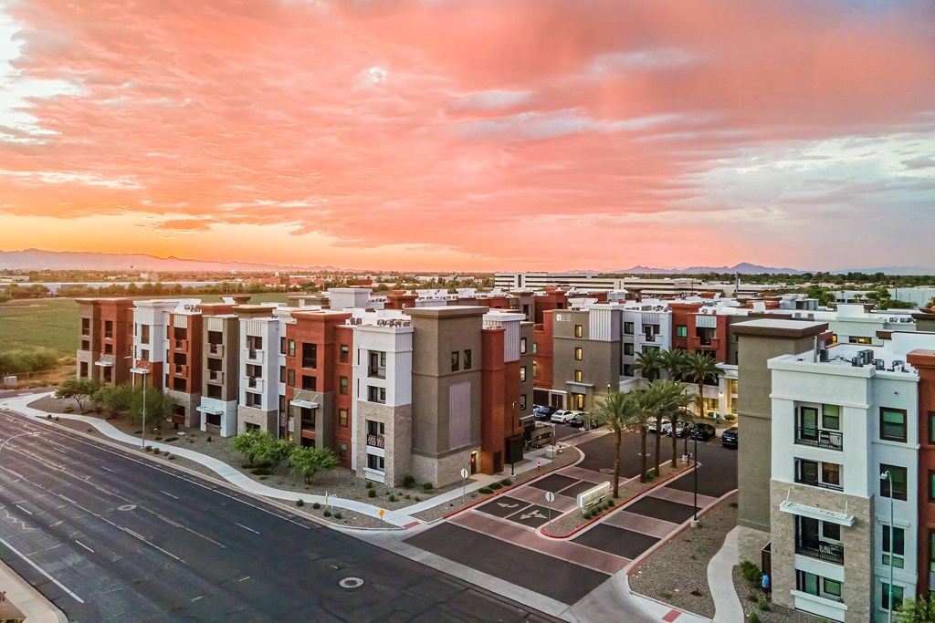 an aerial view of an apartment complex with a sunset in the background