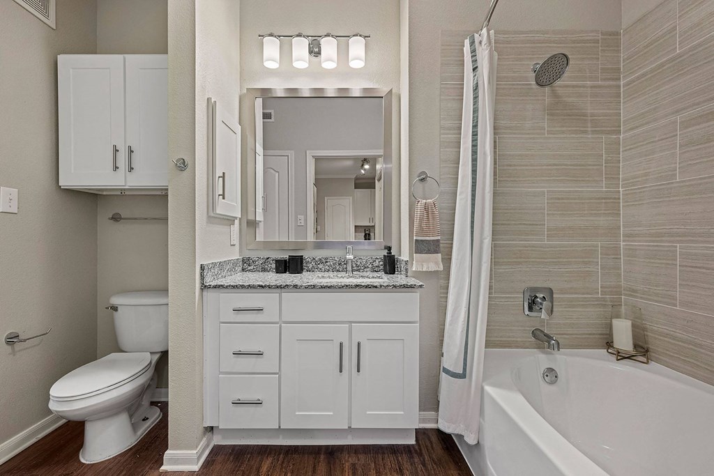 A white bathroom with a toilet, sink, and bathtub.