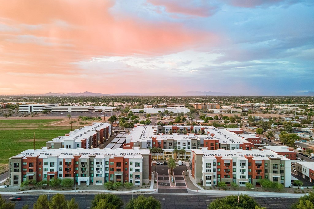 an aerial view of an apartment complex with a sunset in the background