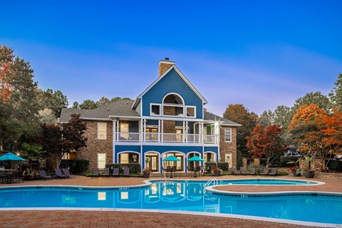 A blue house with a pool in front.