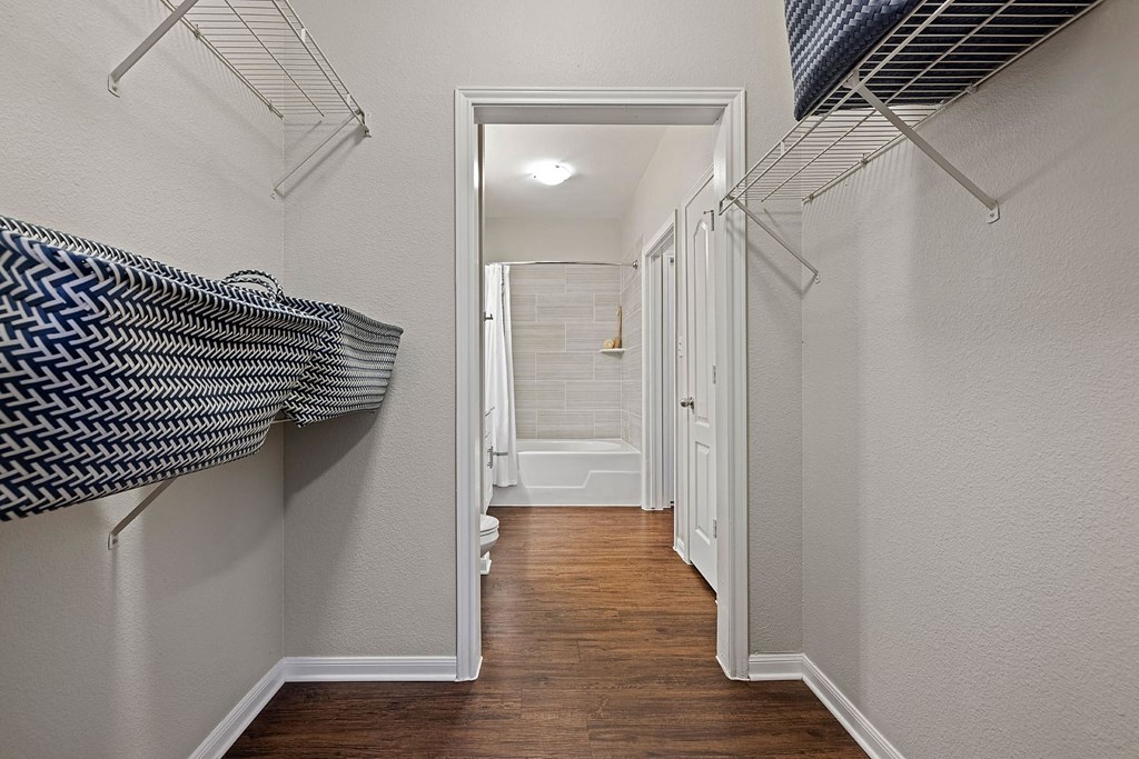 A hallway with a white door and a white wall.