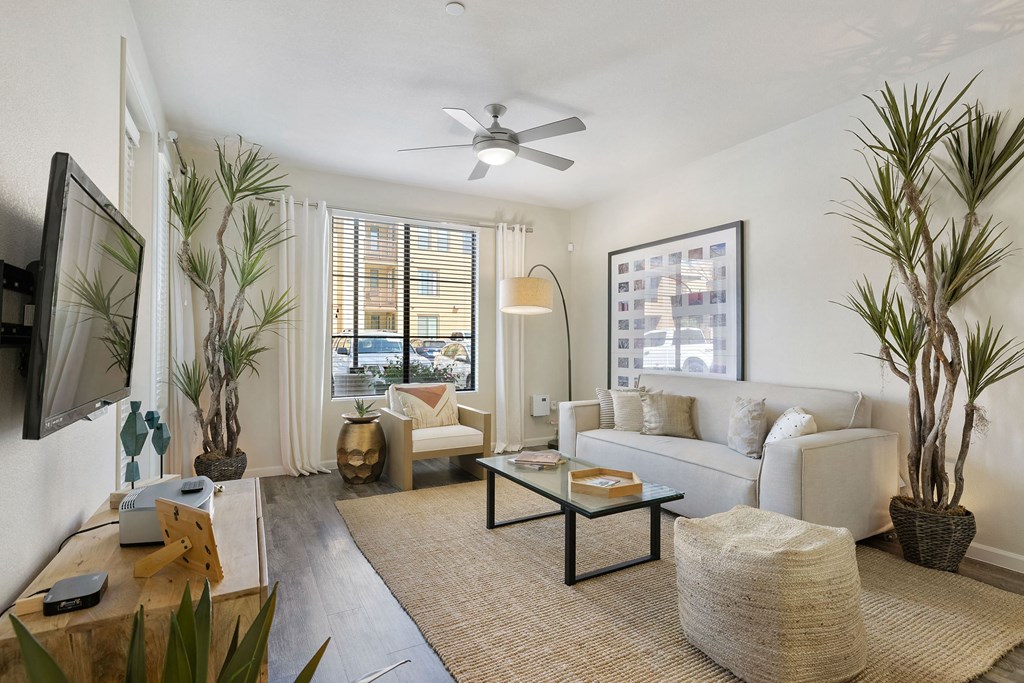 a living room with a white couch and a ceiling fan