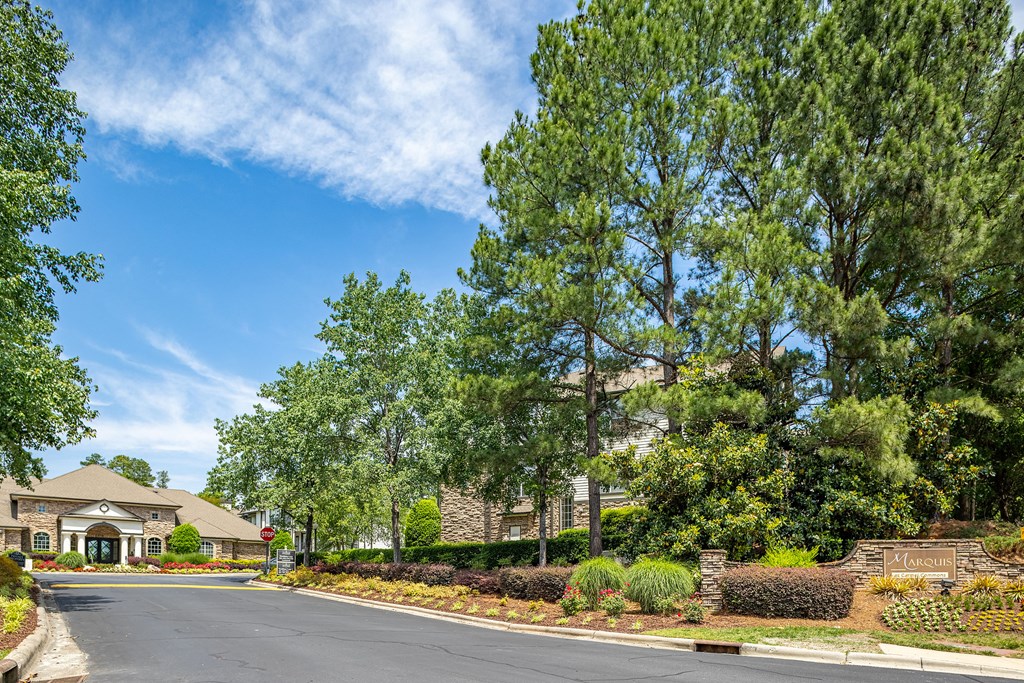 an empty street in front of a building with trees