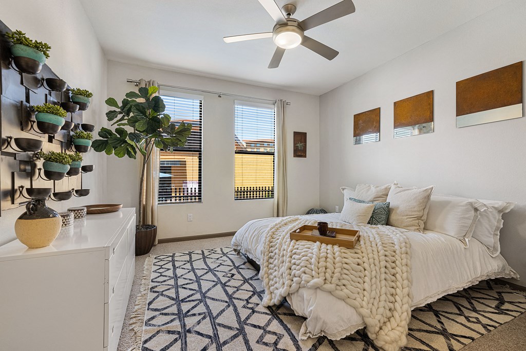 a bedroom with a bed and a ceiling fan
