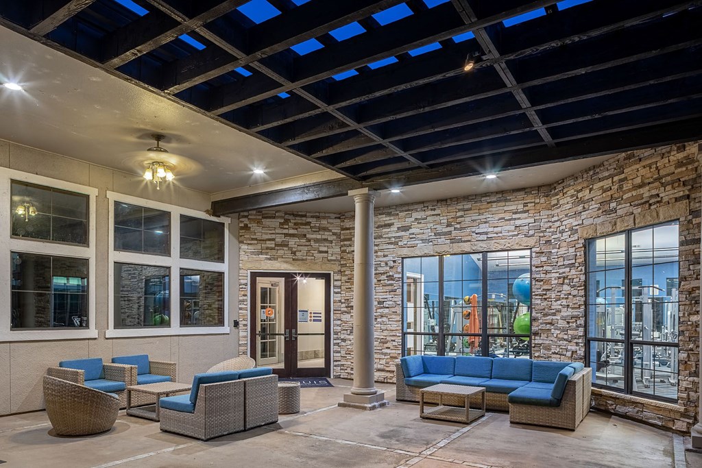 A patio area with a stone wall and furniture.