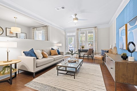 A living room with a white couch and a rug.